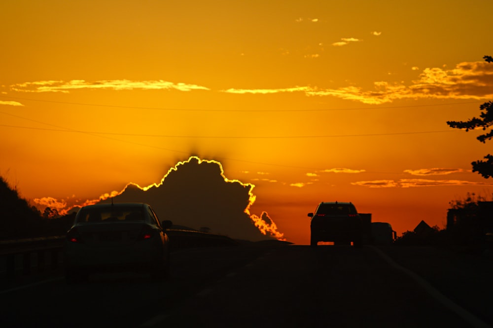 Le soleil se couche sur une route bordée de voitures