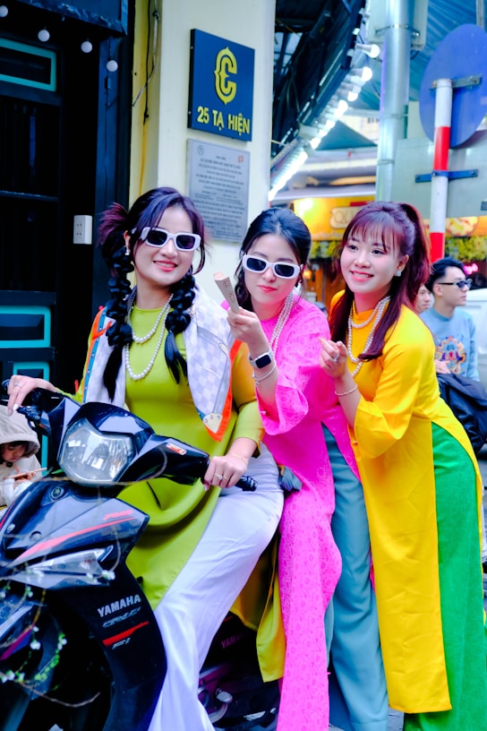 three women are posing for a picture on a motorcycle