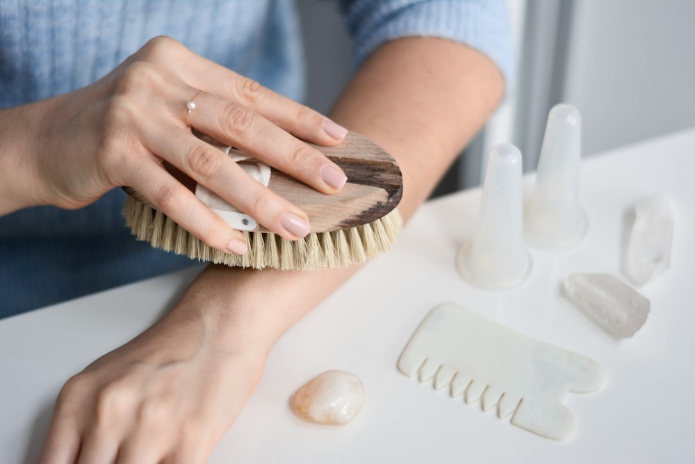 a woman brushes her nails with a brush