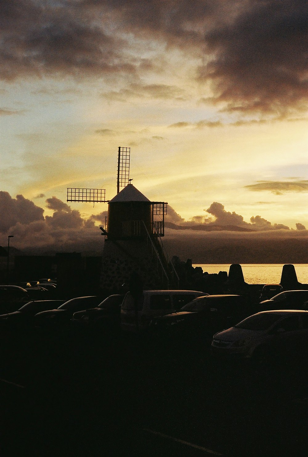 a windmill sitting next to a body of water