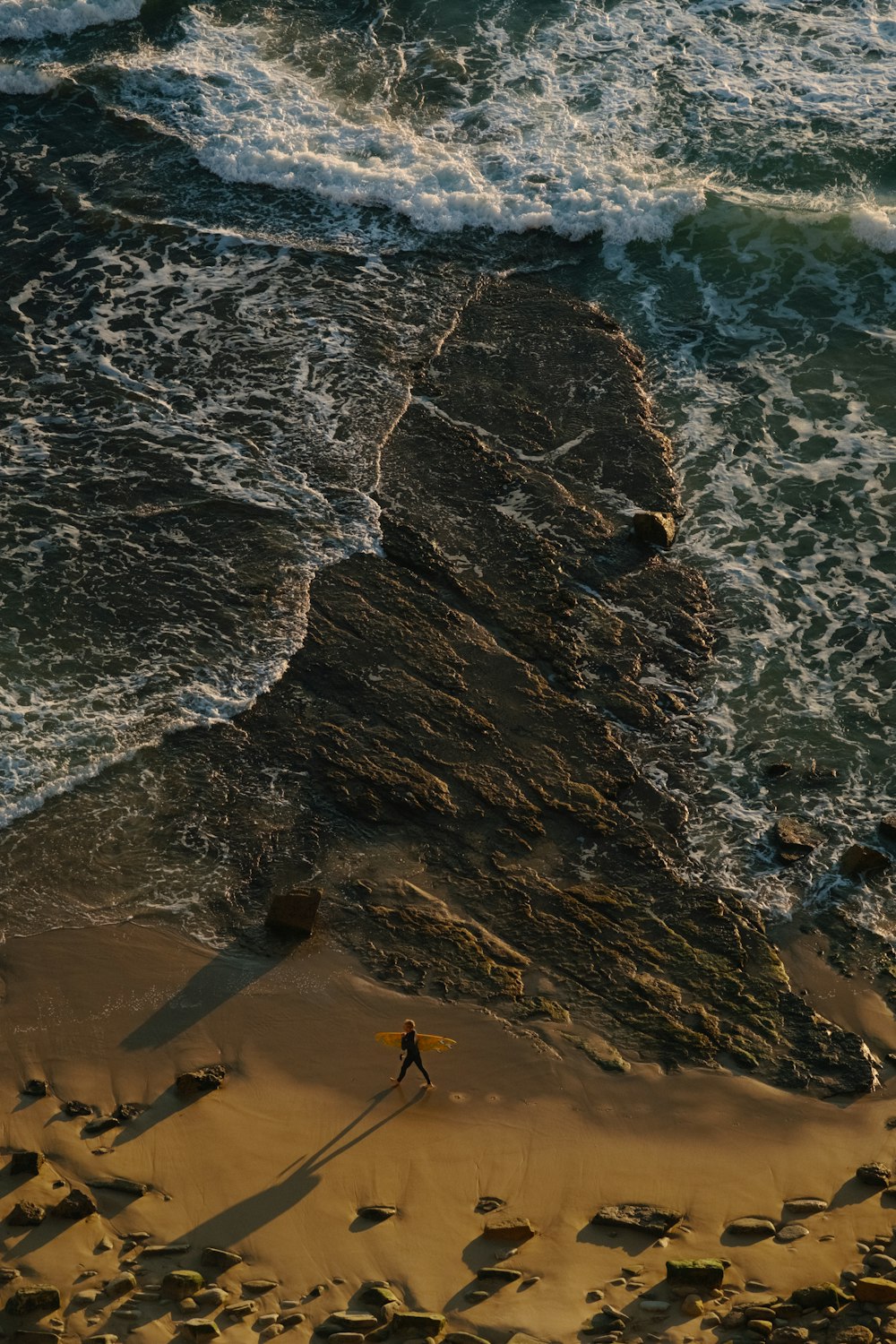 a person walking on a beach next to the ocean