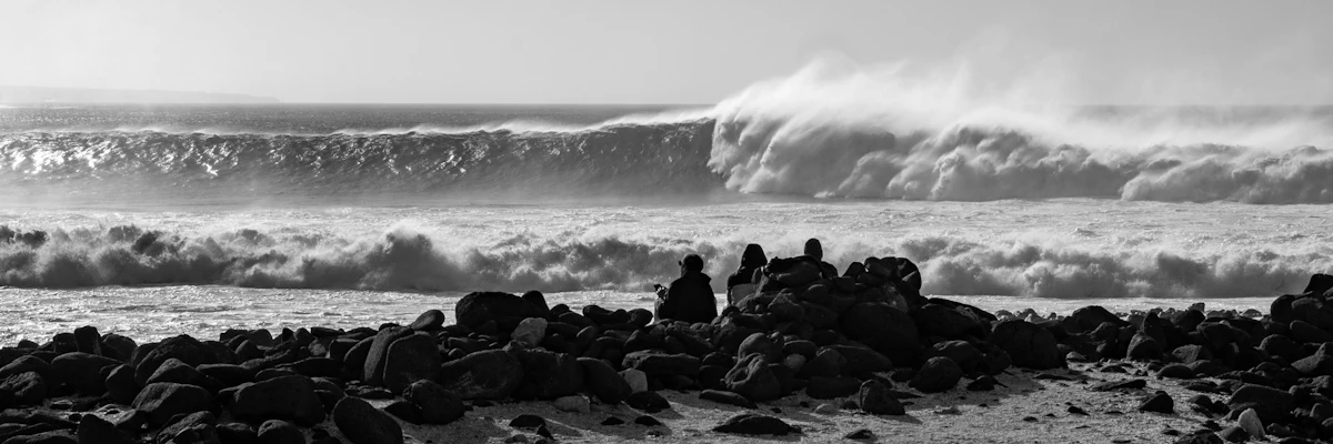 Storm-driven waves breaking against a rocky coastline under grey sky