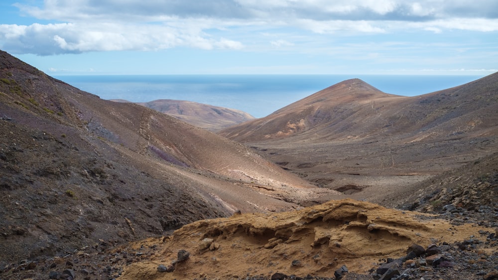 a view of a mountain range from the top of a hill