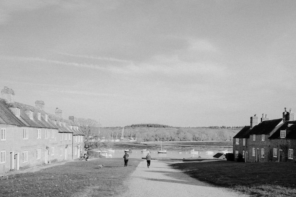 a couple of people walking down a dirt road