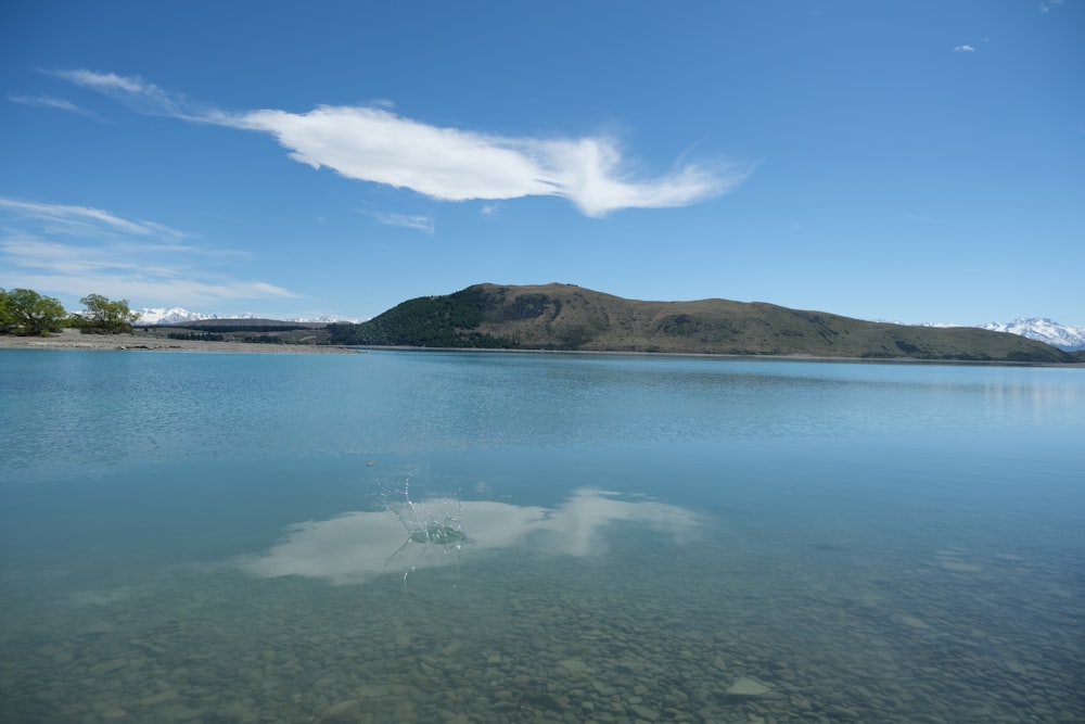 ein Gewässer mit einem Berg im Hintergrund