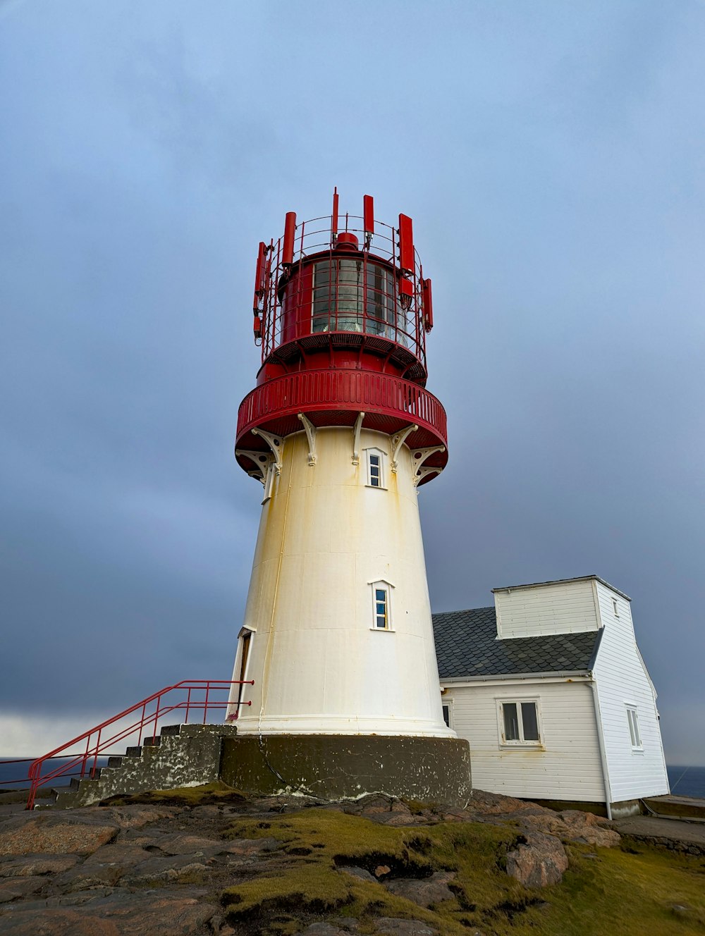 a red and white lighthouse on top of a hill