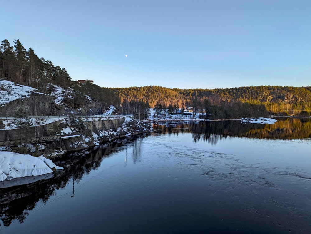 a body of water surrounded by snow covered mountains