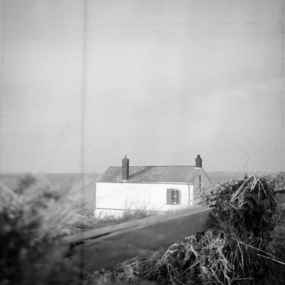 a black and white photo of a house on a hill