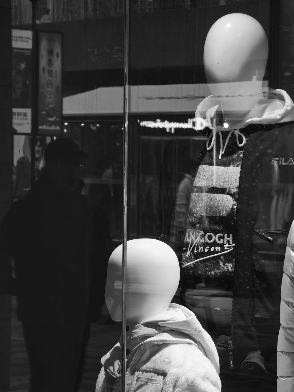 a black and white photo of a mannequin in a window