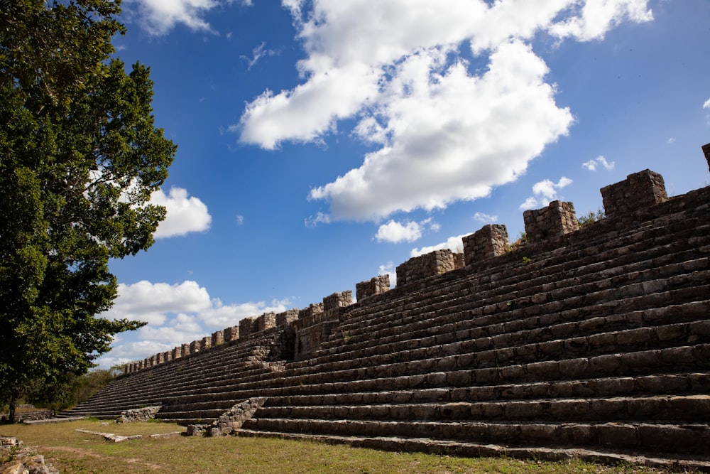 a large stone structure sitting on top of a lush green field