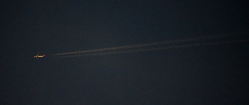 an airplane is flying in the sky at night