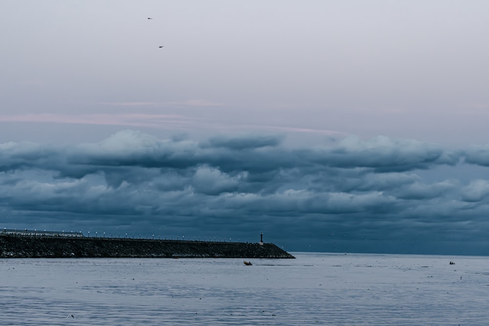 a large body of water under a cloudy sky