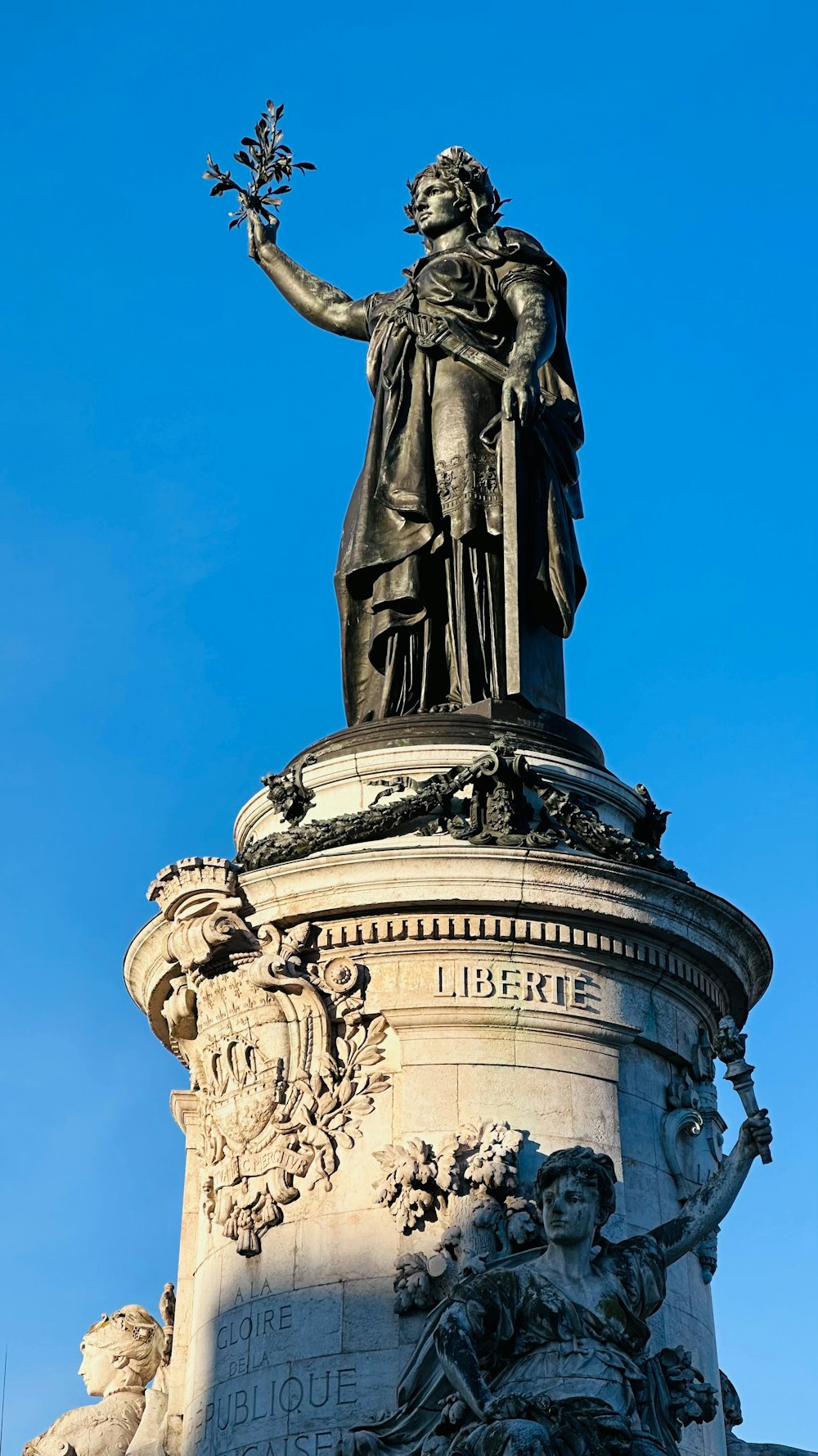 a statue of a man holding a flower on top of a building