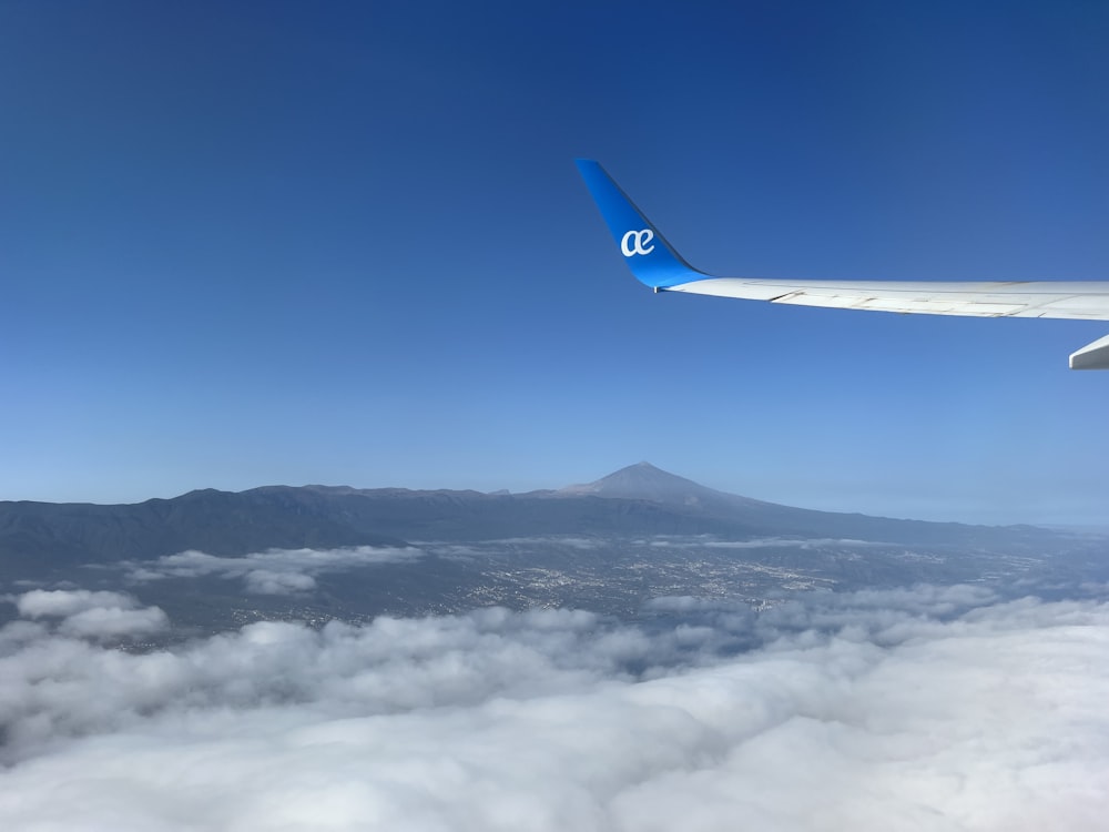 a view of the wing of an airplane flying above the clouds