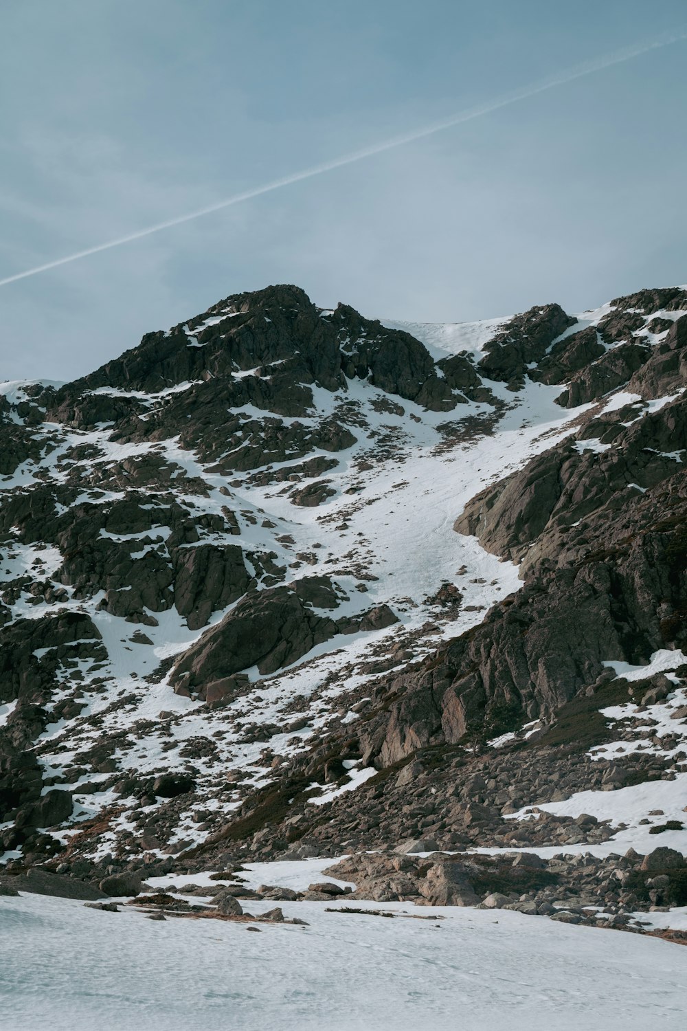 ein schneebedeckter Berg mit einem Skilift im Hintergrund