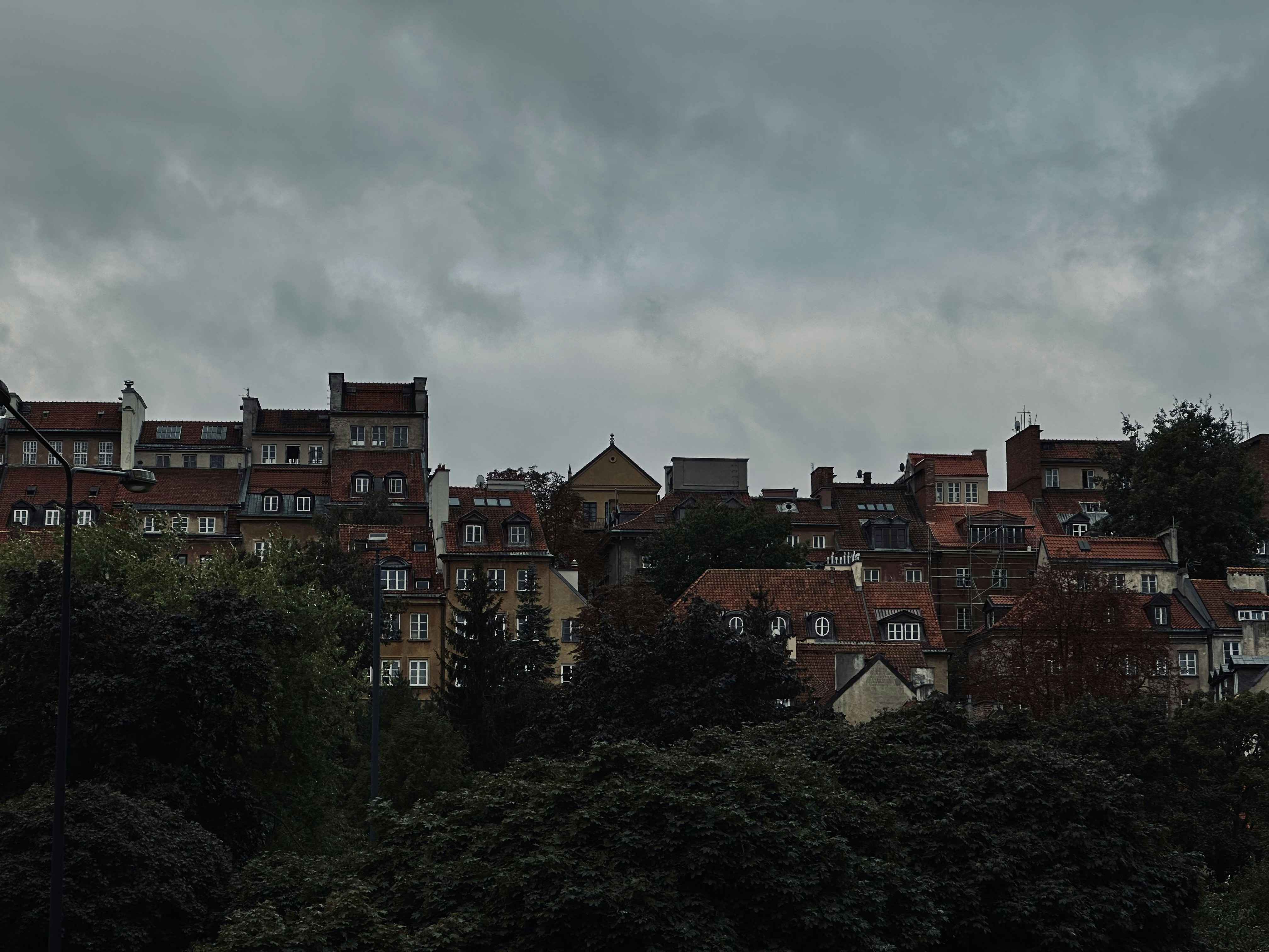 a group of buildings sitting on top of a lush green hillside, 