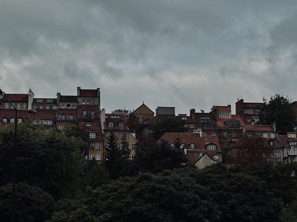 a group of buildings sitting on top of a lush green hillside