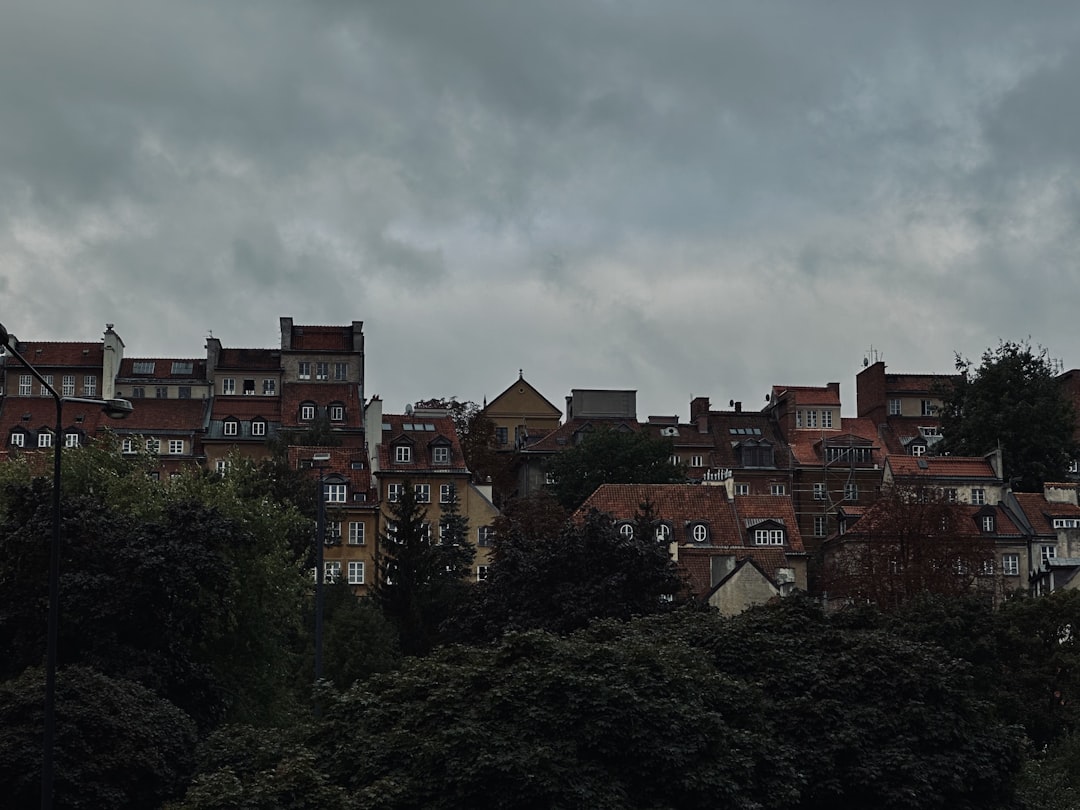 a group of buildings sitting on top of a lush green hillside,