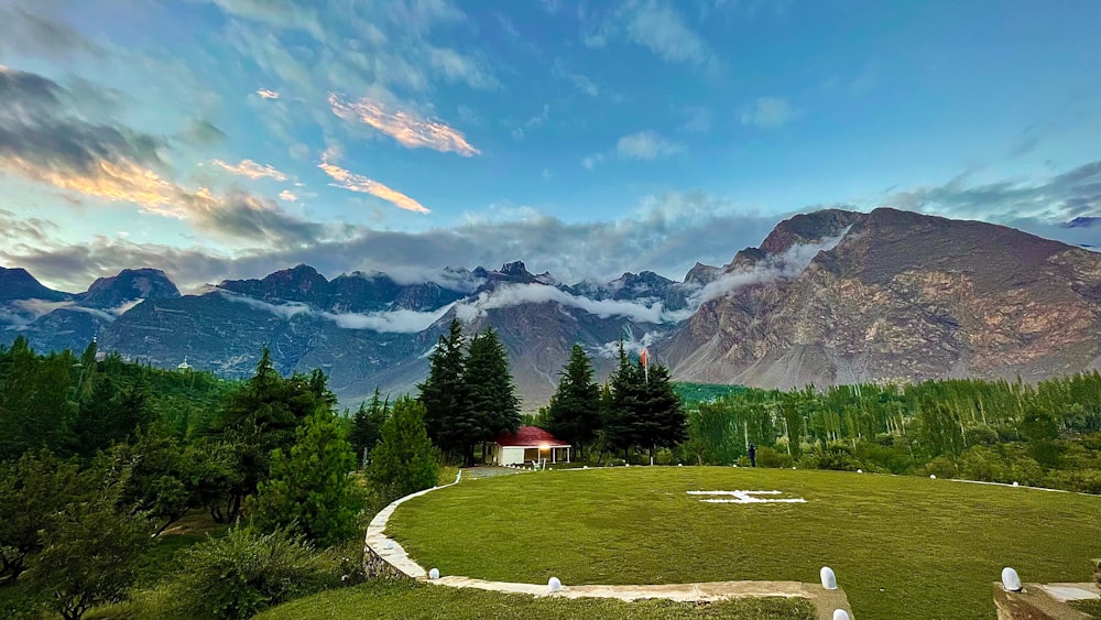 Una vista panorámica de un campo cubierto de hierba con montañas al fondo