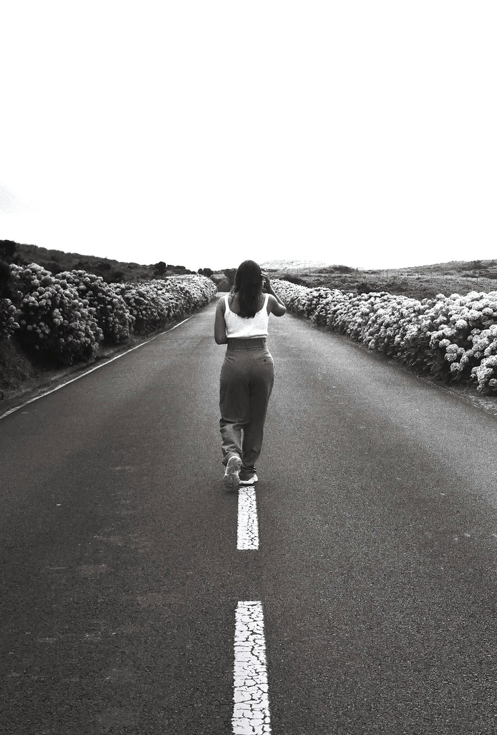 a woman riding a skateboard down the middle of a road