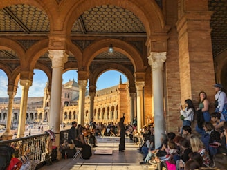 a group of people sitting and standing around a building