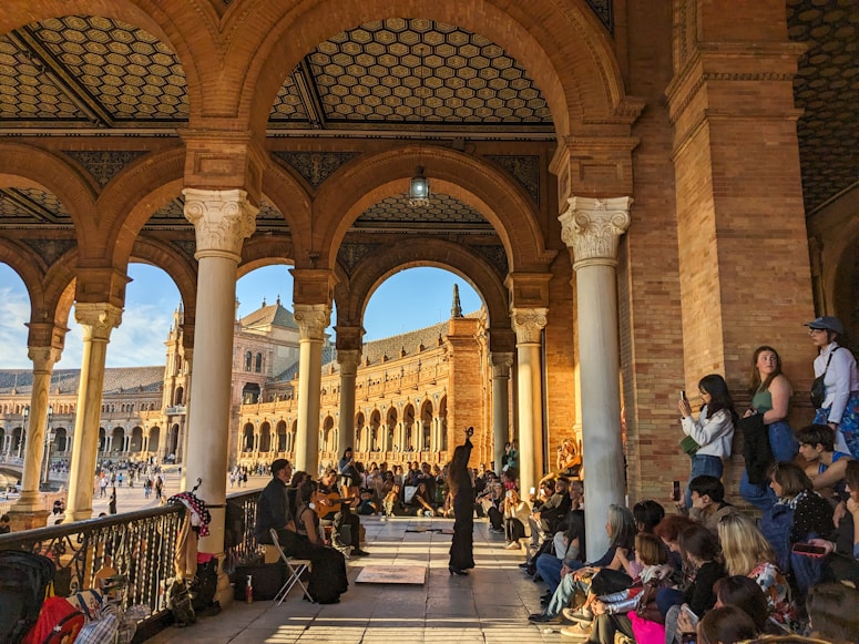 a group of people sitting and standing around a building