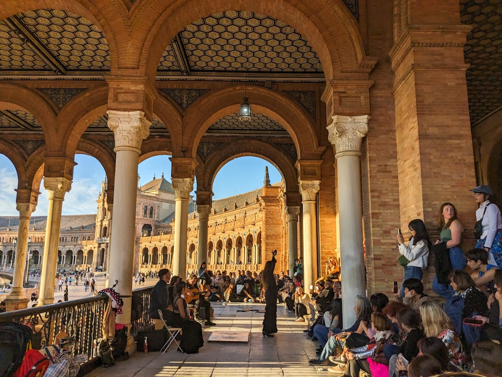 a group of people sitting and standing around a building