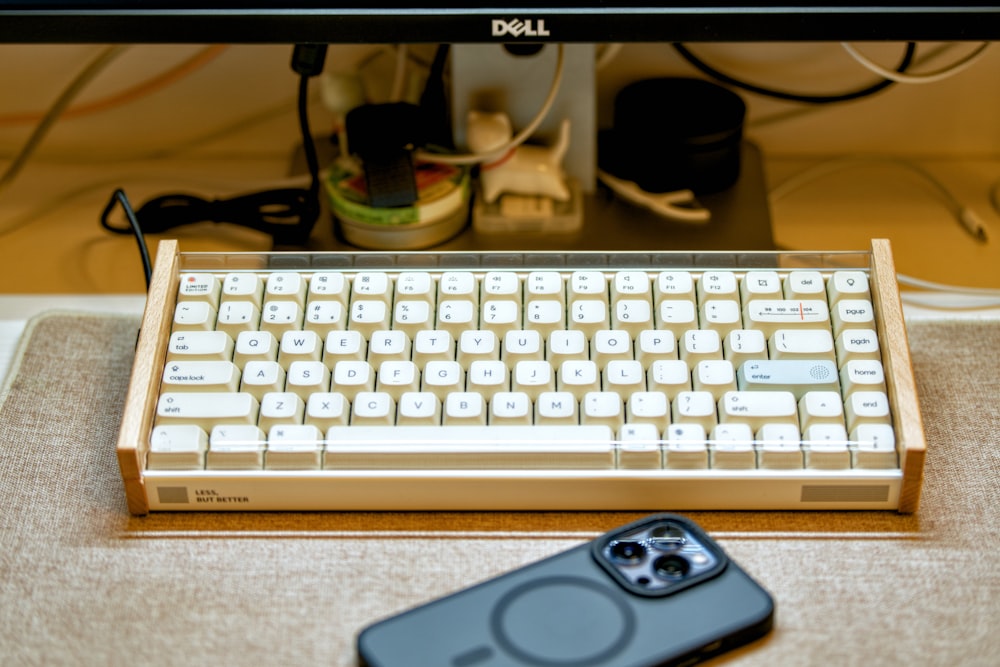 a keyboard and a cell phone sitting on a desk