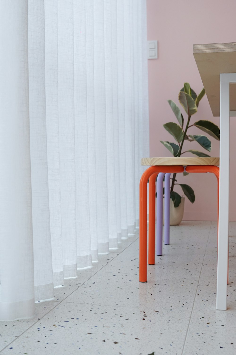 a table with a plant on top of it next to a window