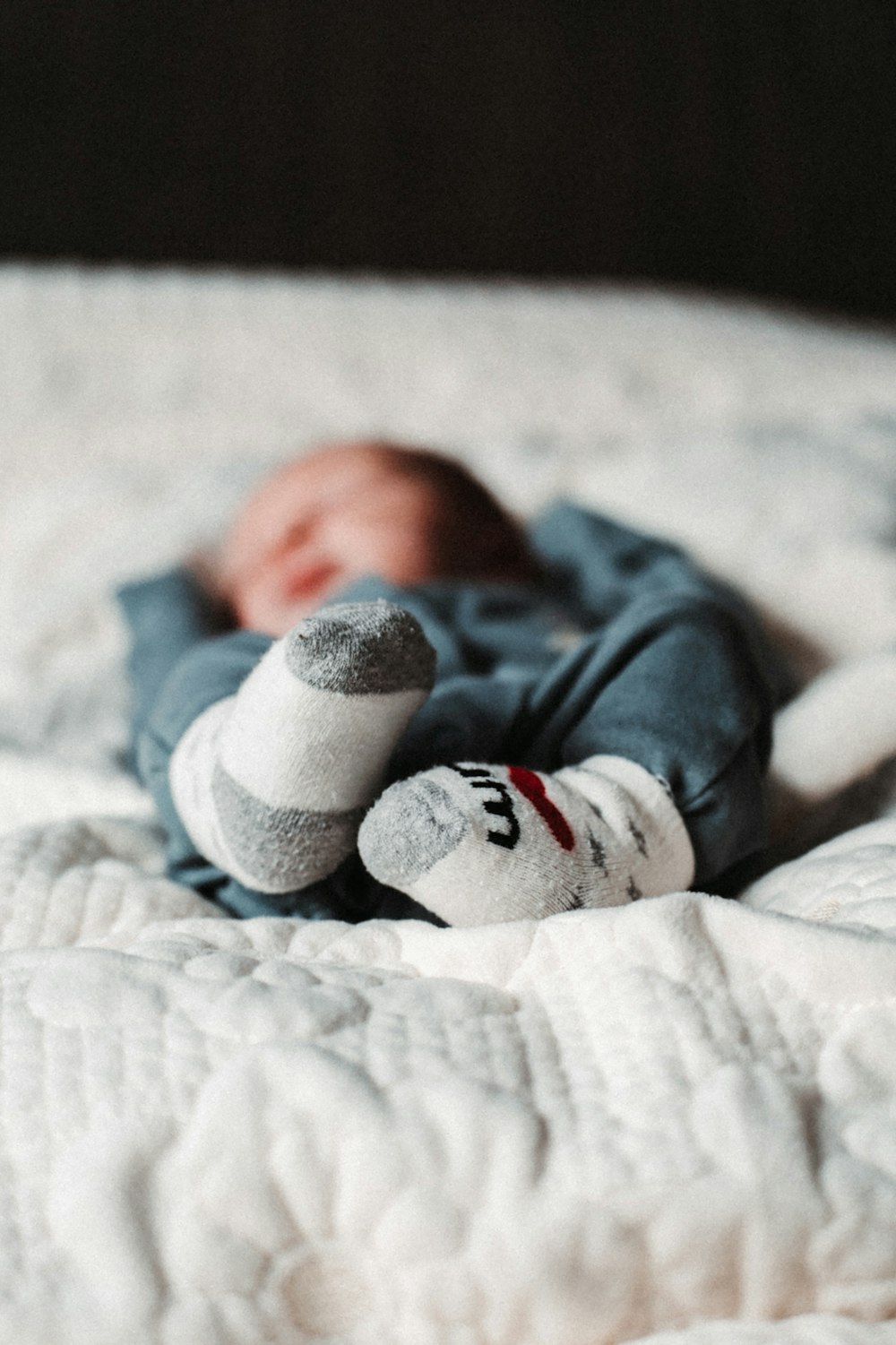 a baby laying on top of a white bed