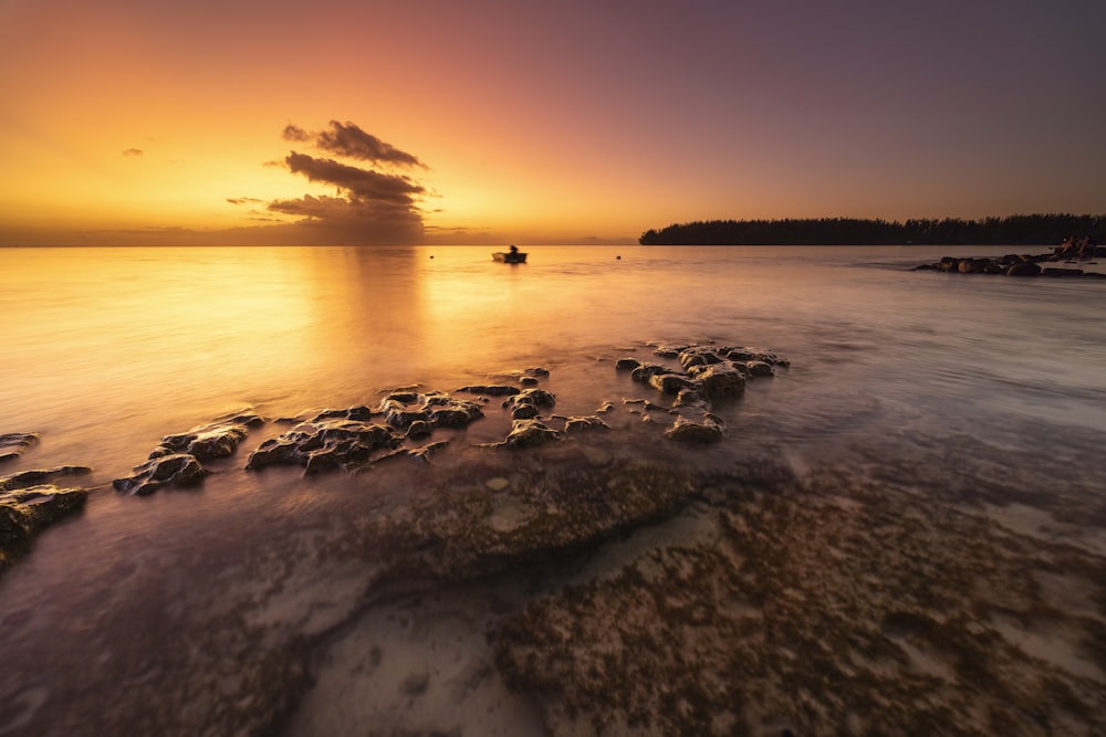 the sun is setting over a body of water