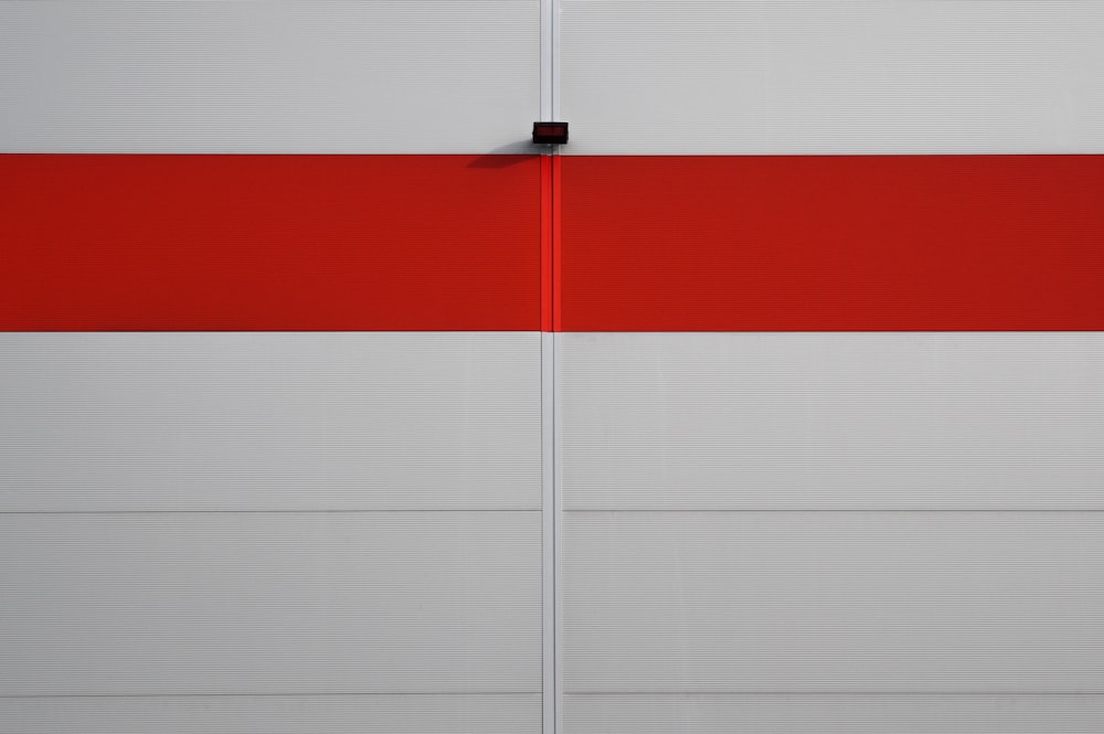 a red and white striped wall with a black pole