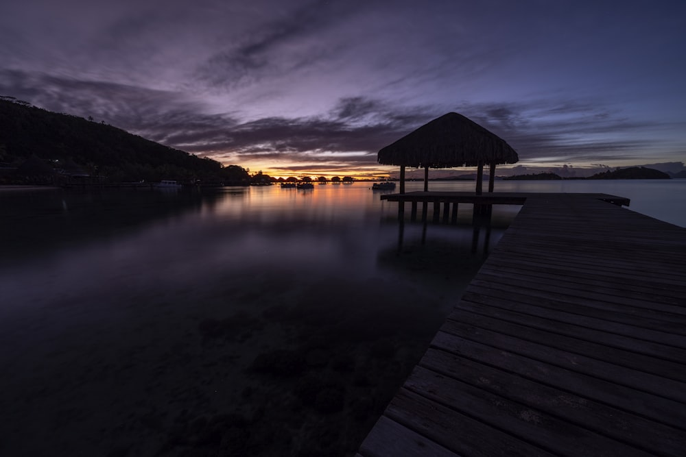 ein Dock mit einer Hütte darauf in der Nacht