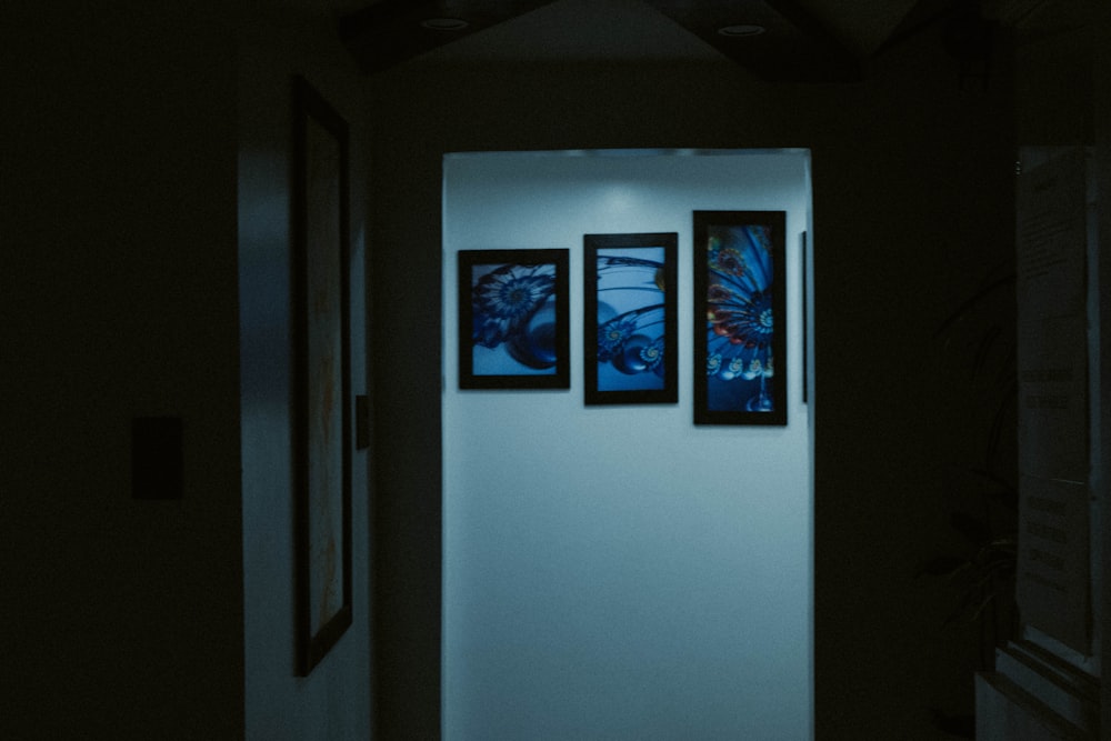 a hallway with three paintings on the wall