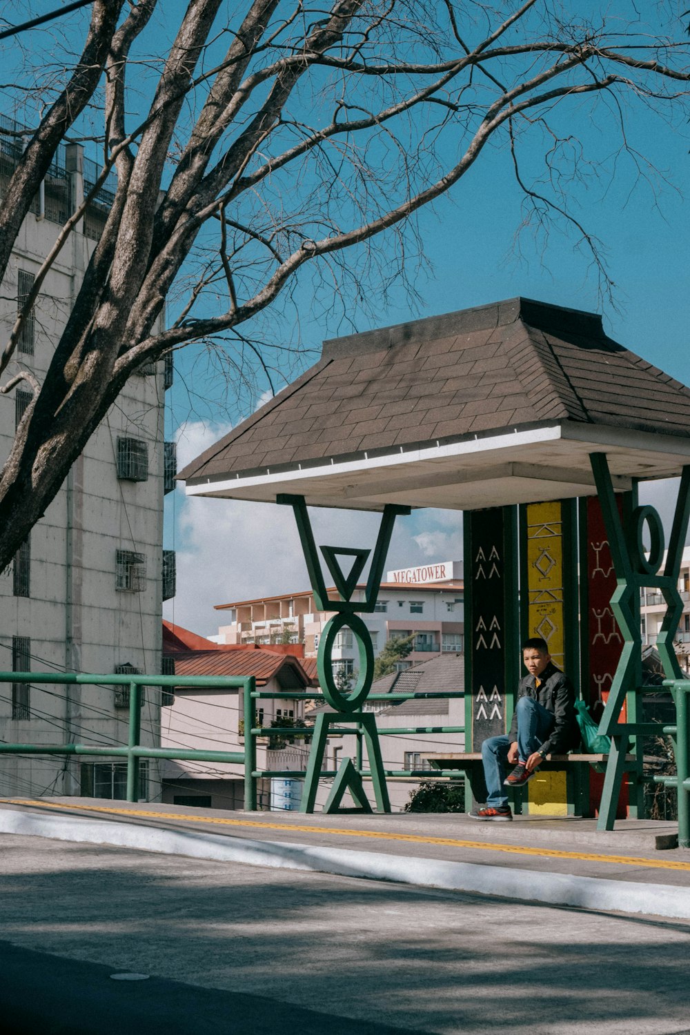 a man sitting on a bench next to a tree