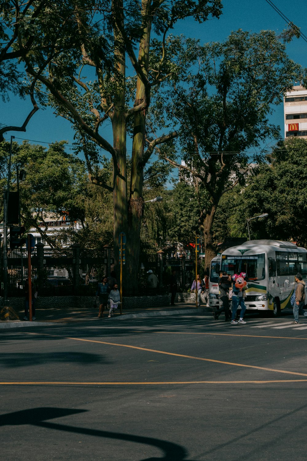 a group of people crossing a street in front of a bus