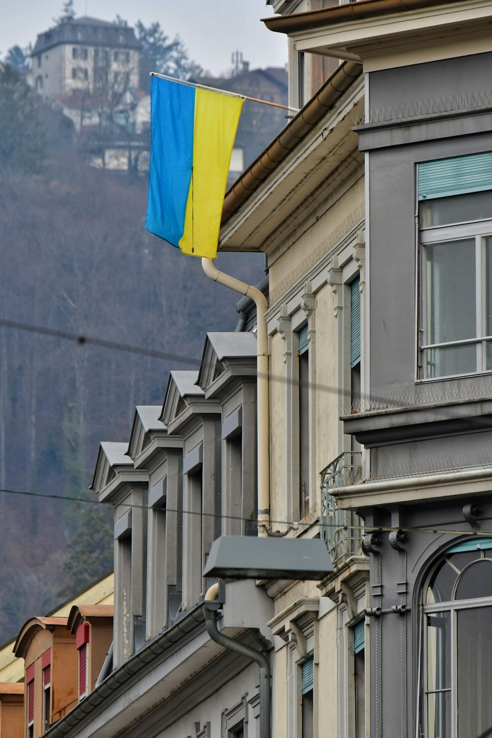 a blue and yellow flag is hanging from a building