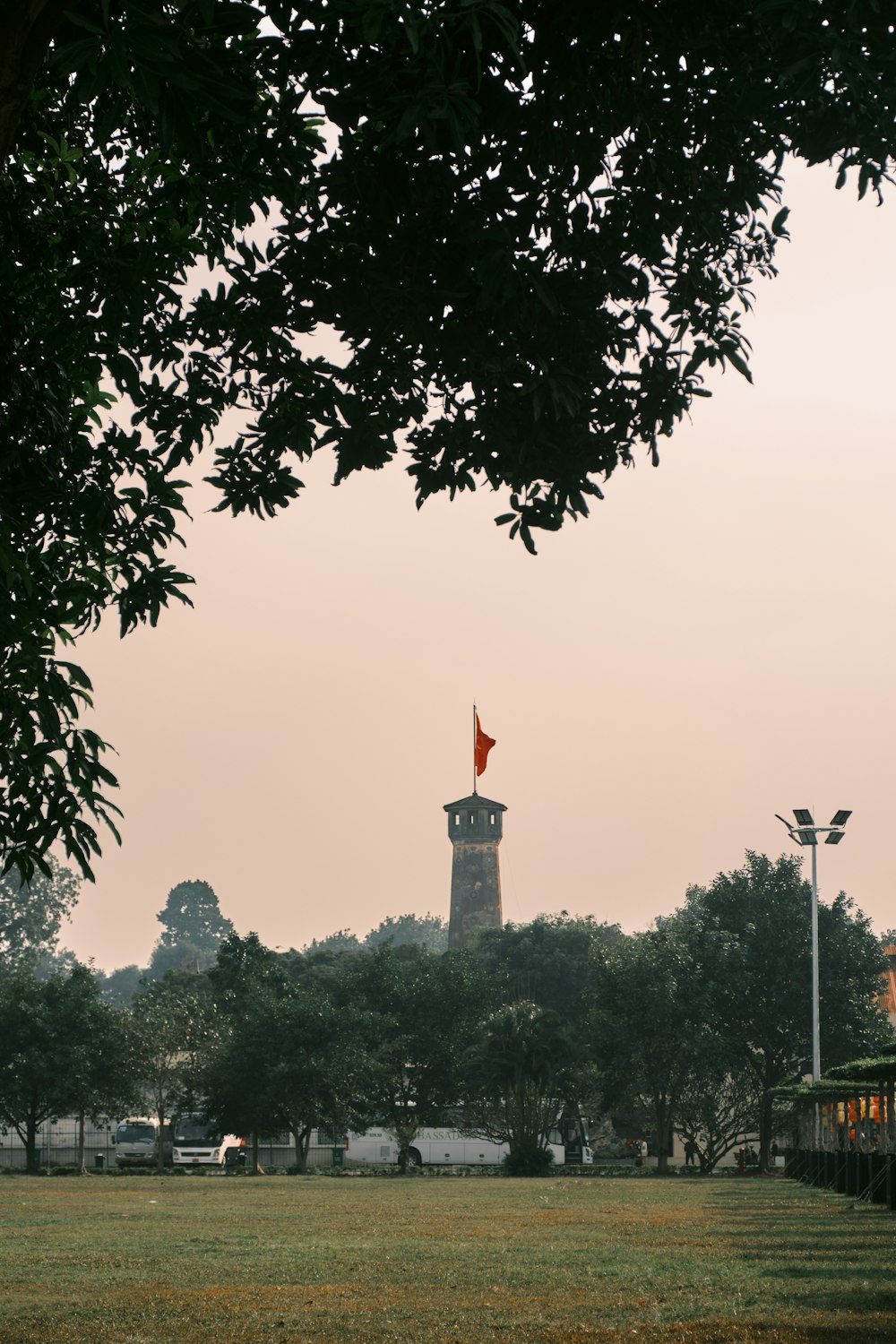 a tall clock tower towering over a lush green park