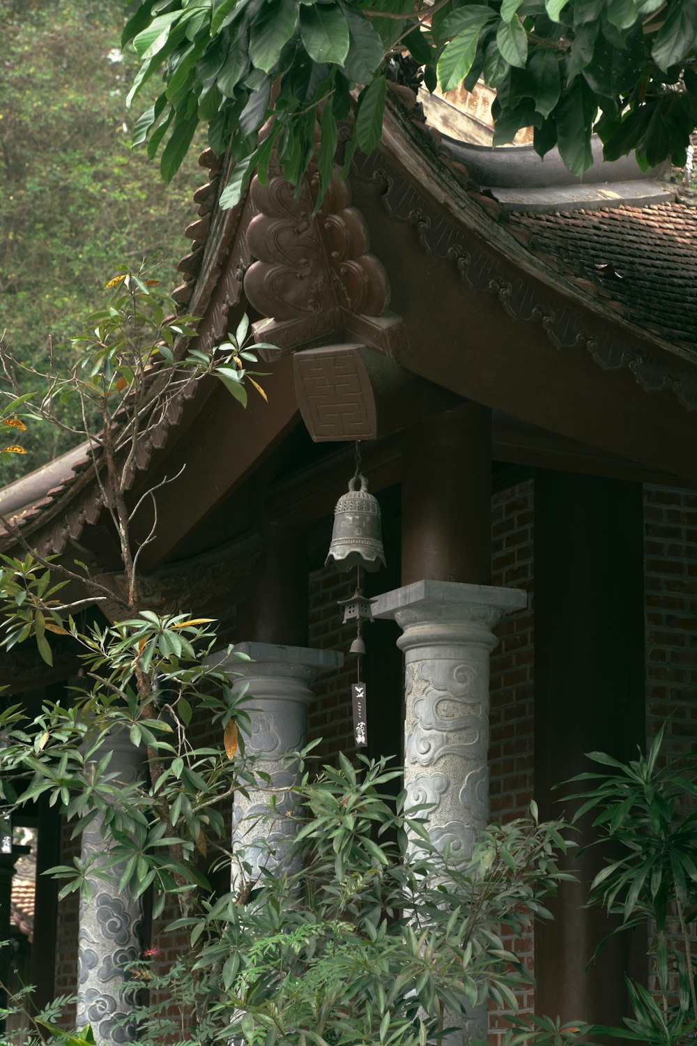 a bell is hanging from the roof of a building