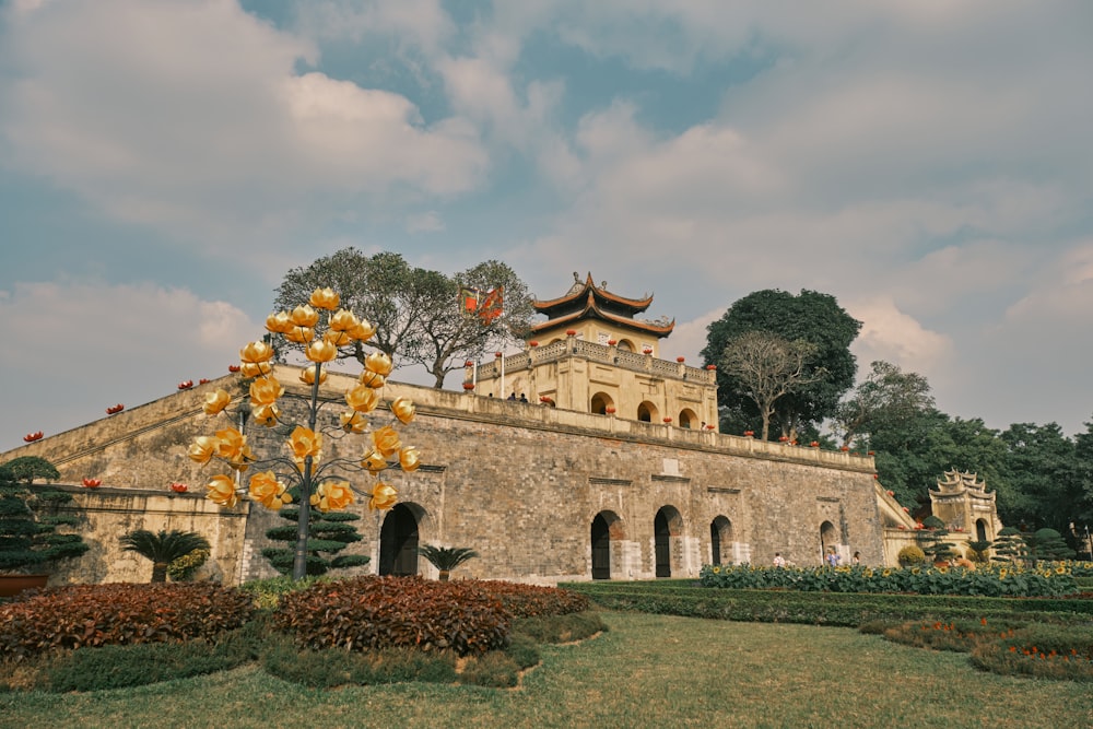 a stone building with a yellow tree in front of it