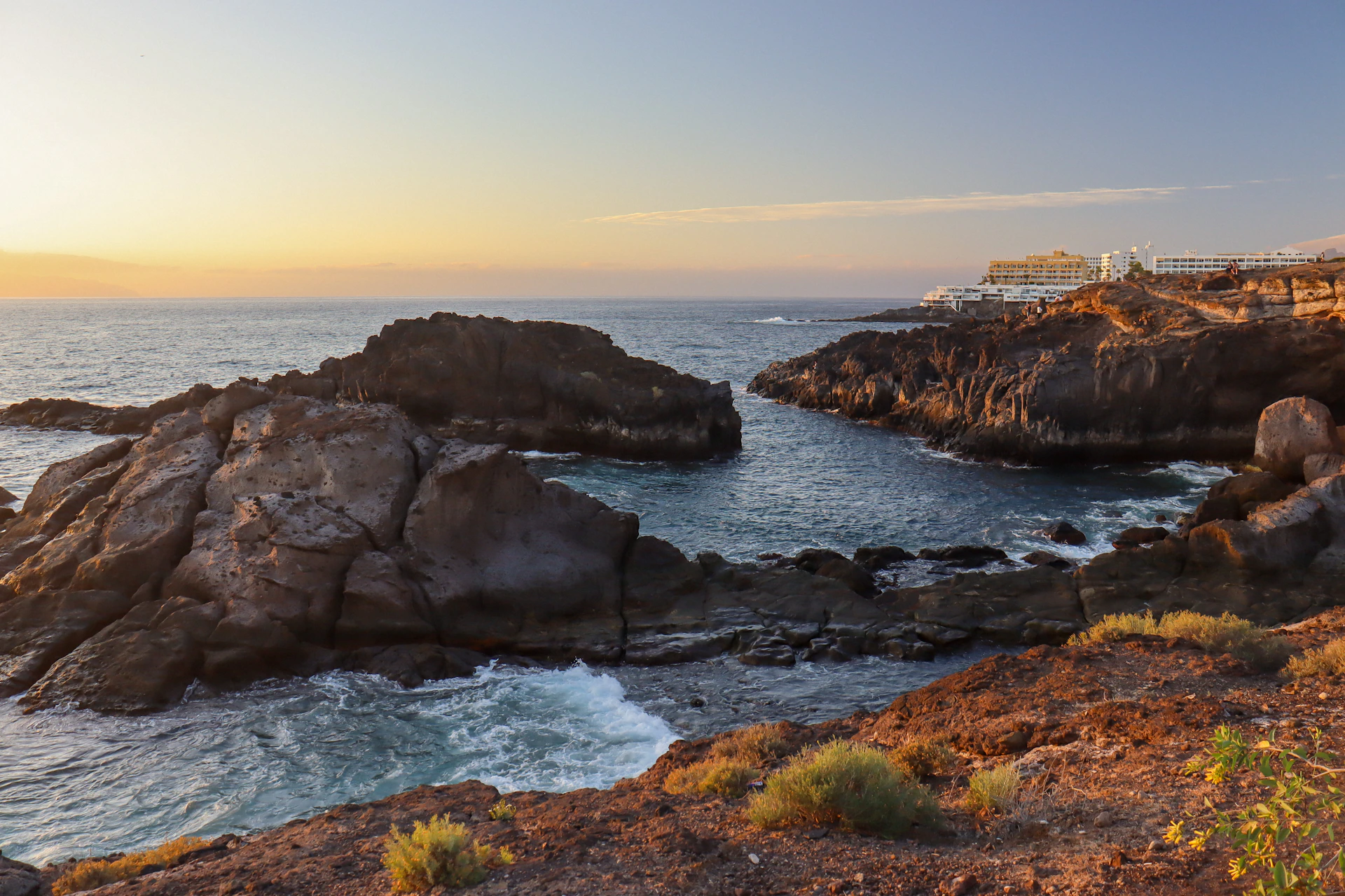 a view of the ocean from a rocky shore