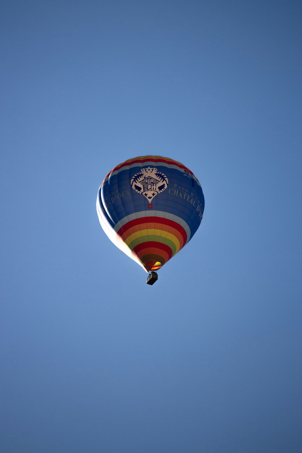 a colorful hot air balloon flying through a blue sky