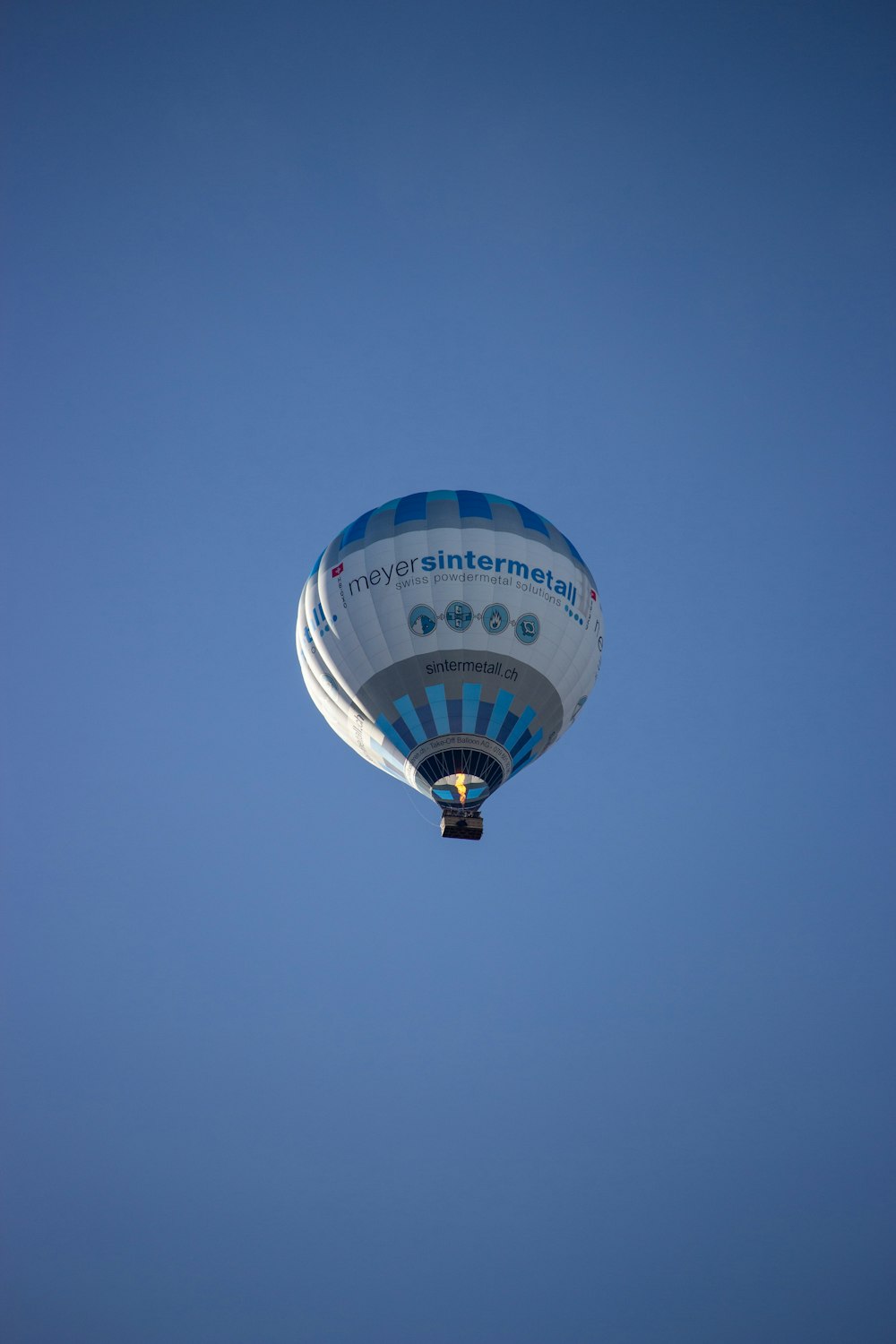 a hot air balloon flying through a blue sky