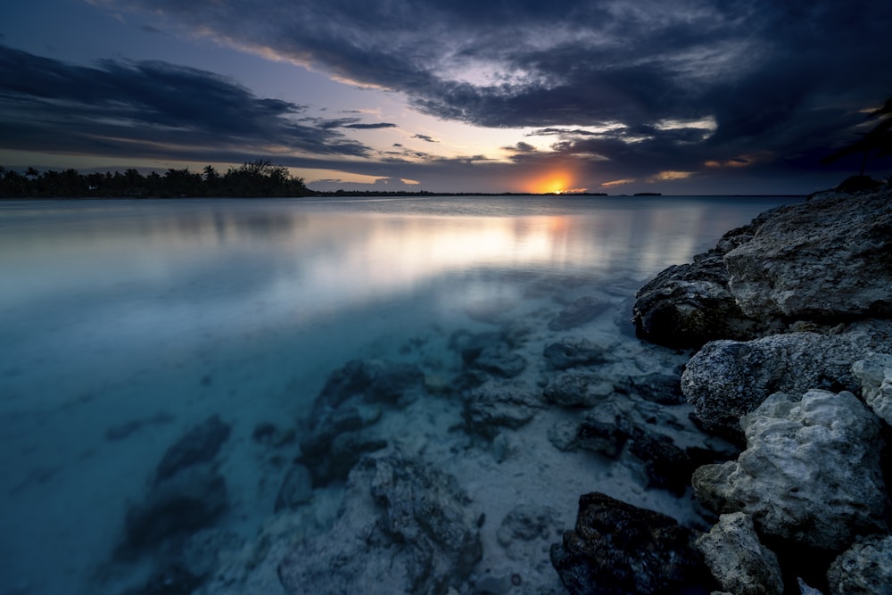 the sun is setting over a body of water