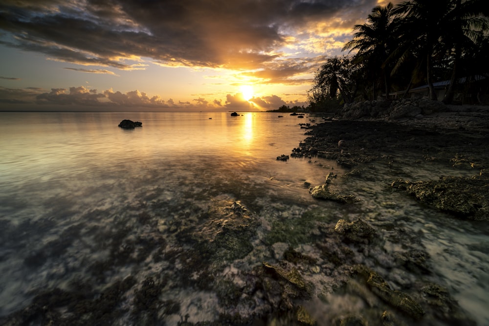 the sun is setting over a body of water