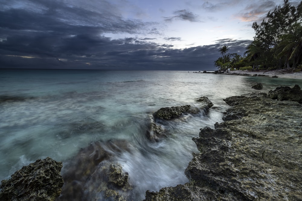 a rocky shore with a body of water in the foreground