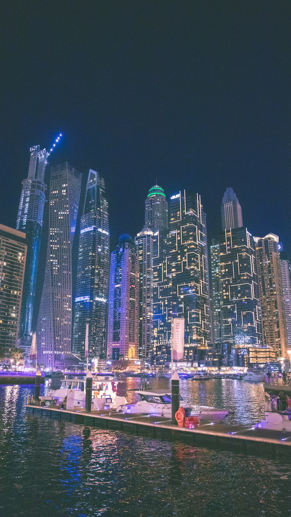 a city skyline at night with boats in the water