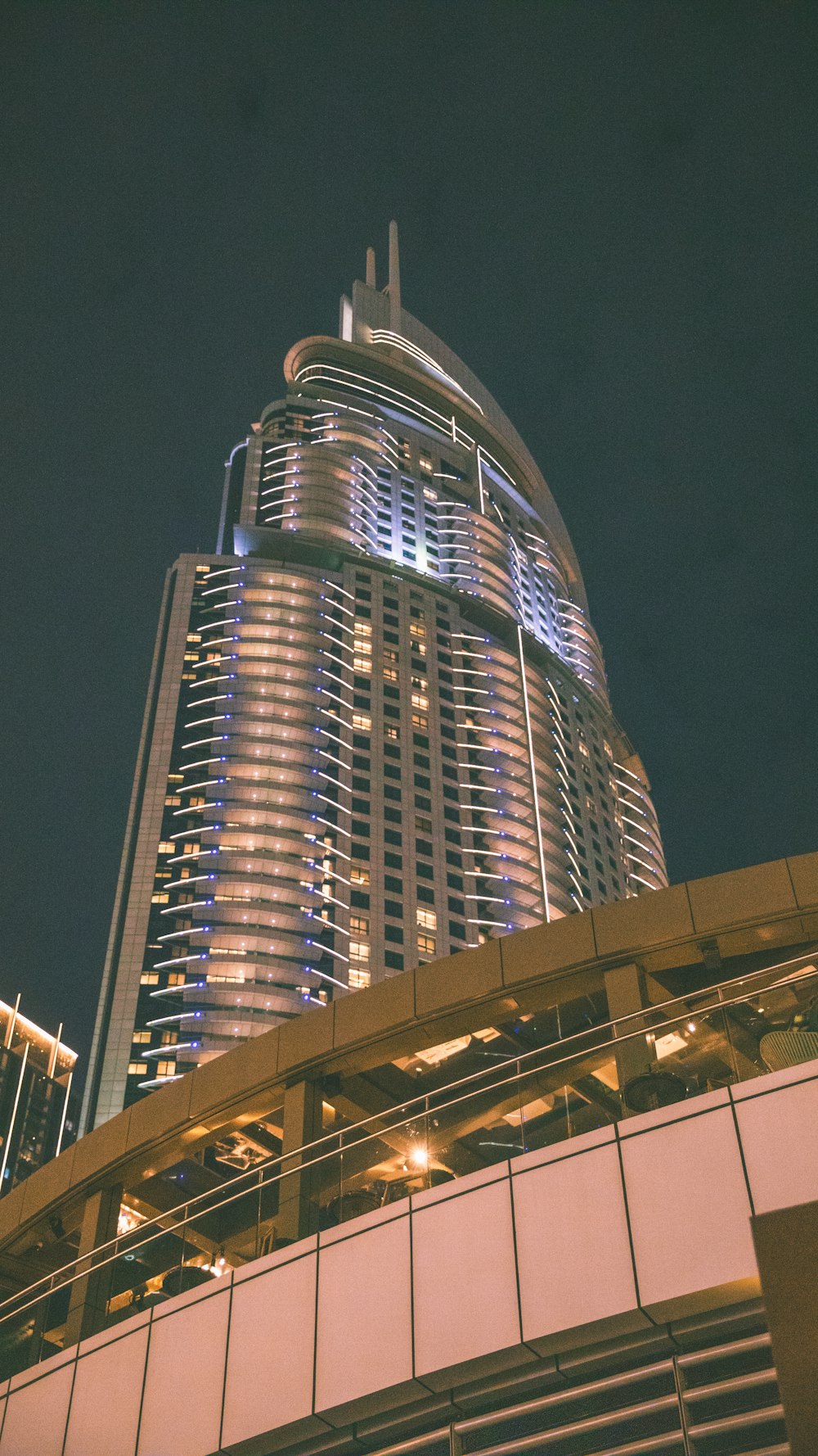 a tall building lit up at night in the city