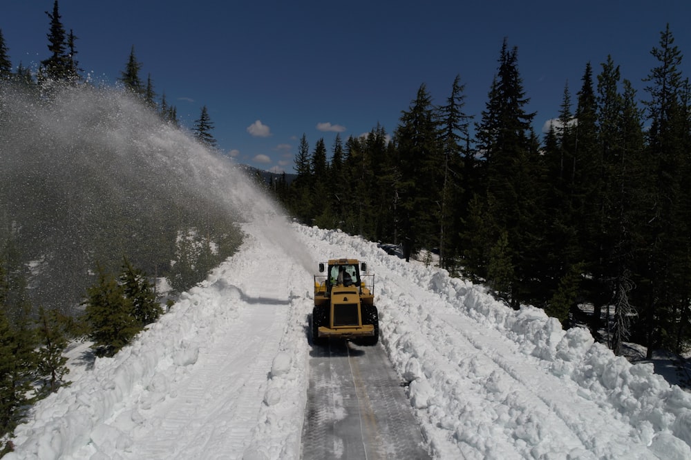 a snow plow driving down a snow covered road