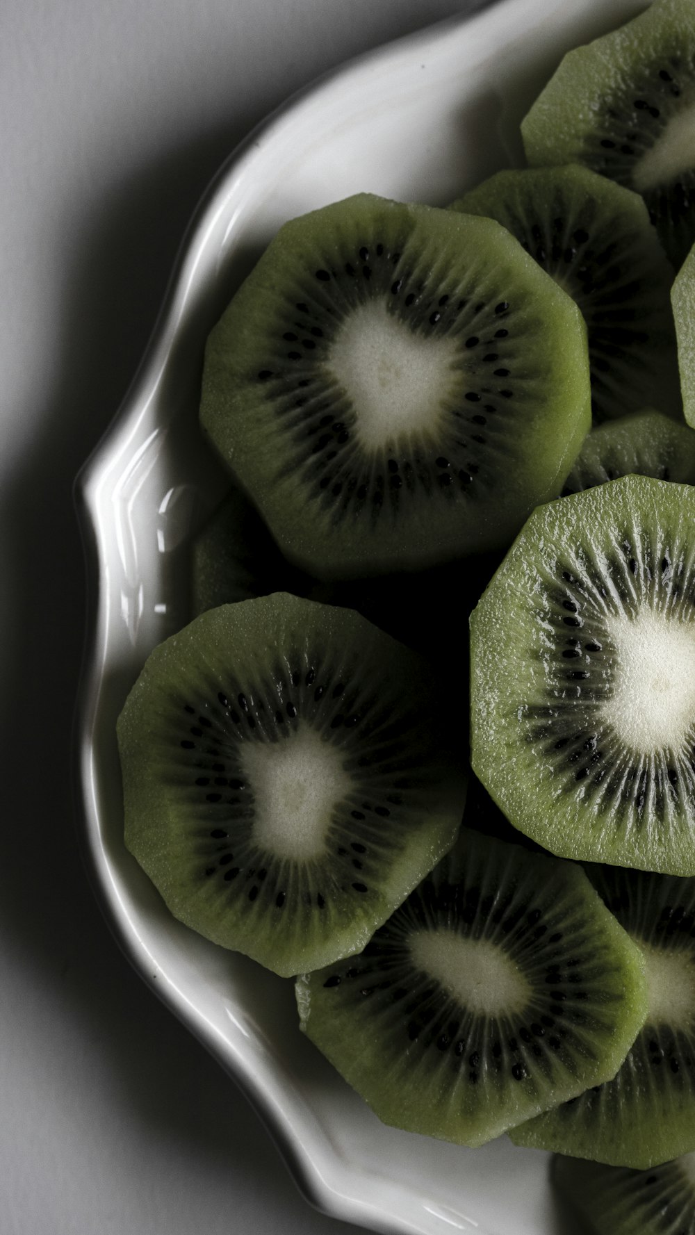 a white bowl filled with kiwi slices on top of a table